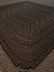 Fototapeta premium Fertile, darkish, fine-grained soil mass, view from above onto freshly plowed land