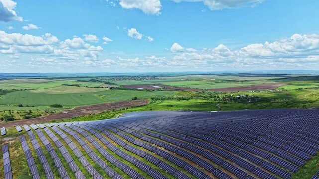 Panoramic solar array stretching across countryside under expansive sky with fluffy clouds orderly rows of panels absorb bright sunlight, farmland integration