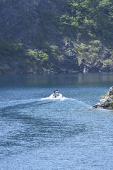 Fototapeta premium Motorboat with Two People on a Mountain Lake