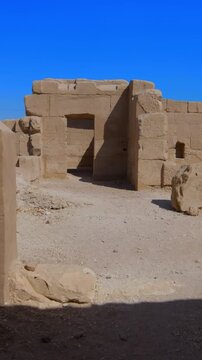Seti I mortuary temple exterior with Osiride colonnade and palm trees in Luxor