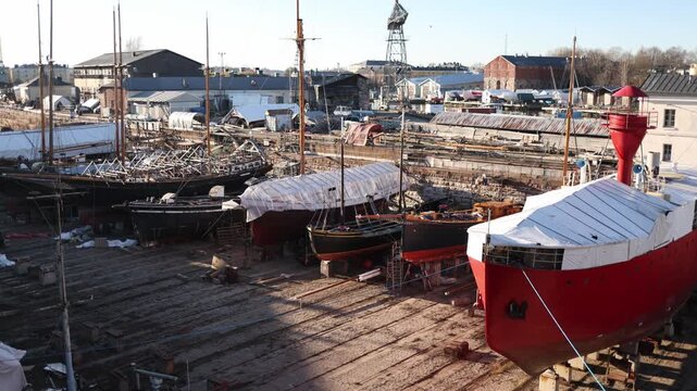 Dry dock for ship maintenance with drained water exposing large vessel during repair process inside industrial shipyard facility