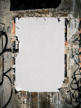 Distressed blank paper poster mockup on weathered concrete wall with torn layered edges graffiti details urban decay texture and authentic street advertising aesthetic