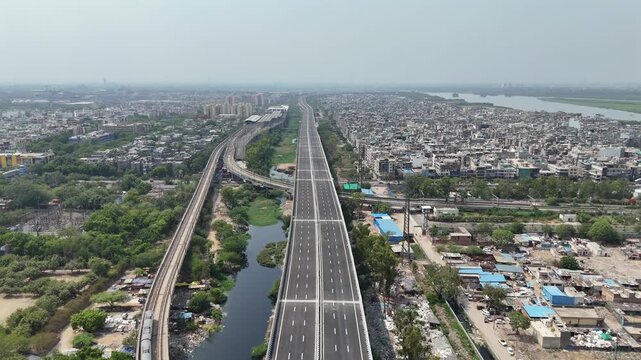 Aerial drone view of Delhi Mumbai Expressway corridor and Delhi Metro near Kalindi Kunj, Delhi India