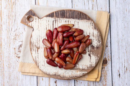 Cooked pinions or araucaria seeds on a board over wooden table