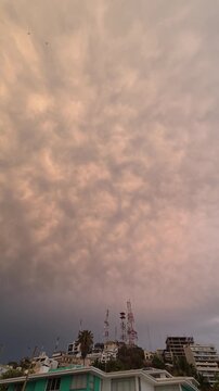 V&iacute;deo vertical en 4K de nubes con texturas espectaculares, iluminadas por la c&aacute;lida luz del atardecer sobre un horizonte urbano. Fondo atmosf&eacute;rico con densas formaciones nubosas y cielo melanc&oacute;lico 