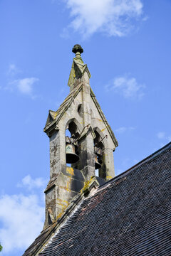 Traditional old fashioned church bells on an old church steeple in Shropshire UK. The steeple has been carved of old local stones.