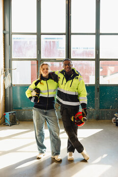 Full length portrait of male and female young student posing together while standing in training hub at vocational schoo