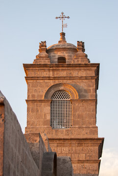Old stonework church tower in Peru bathing in setting sun light