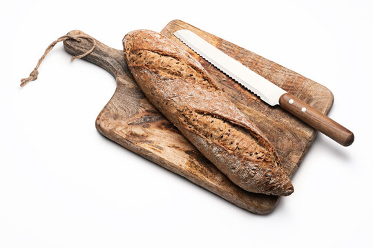 Freshly baked rustic bread baguette with seeds on wooden cutting board isolated on white background