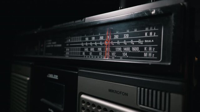 Close-up view highlights the detailed frequency scale and red tuning needle on an old vintage radio. Concept of retro audio technology, nostalgic broadcasting, and classic radio communication.