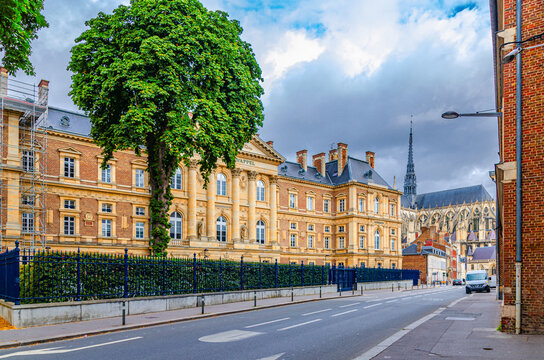 Palace of Justice Palais Cour d'Appel neoclassical architecture style building and Amiens Cathedral in historical city centre, cloudy sky background, Somme department, Hauts-de-France Region, France