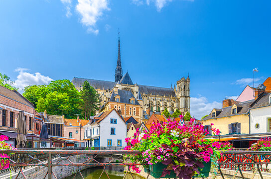 Amiens cityscape old town Saint-Leu quarter with old houses, water canal, fence flowers and Amiens Cathedral Roman Catholic church in historical city centre, France landmarks, Hauts-de-France Region