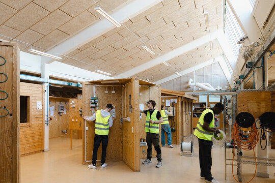 Young multiracial male students training in civil engineering workshop at vocational school