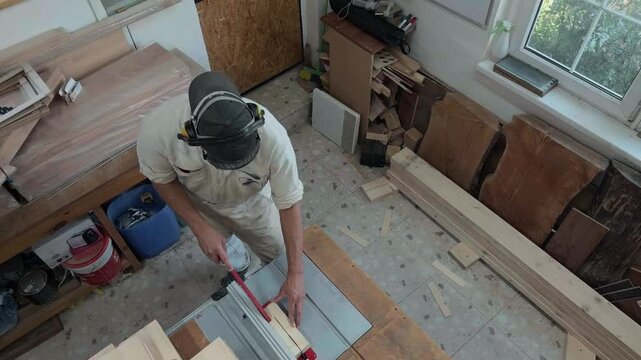Maker in full protective gear continues table saw operation on raw timber inside industrial loft observe zenith perspective high ceiling dynamic suspend handheld sway observational documentary