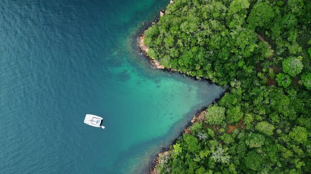 Aerial view of the lush green coastline with boat anchored in the shallows