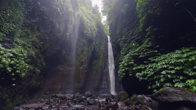 Wide Angle View of Hidden Waterfall Surrounded by Dense Tropical Vegetation and Dramatic Canyon Walls, Natural Wonder and Wilderness