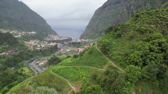 Aerial tracking shot from right to left showcasing scenic Sao Vicente valley panorama and ocean
