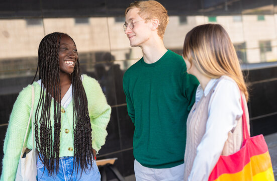 Three Diverse Young Students Chatting and Laughing Outside University Building