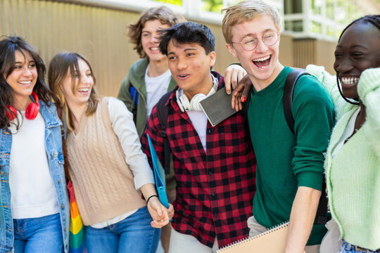 Joyful Male Students of Different Ethnicities Laughing with Arms Around Each Other