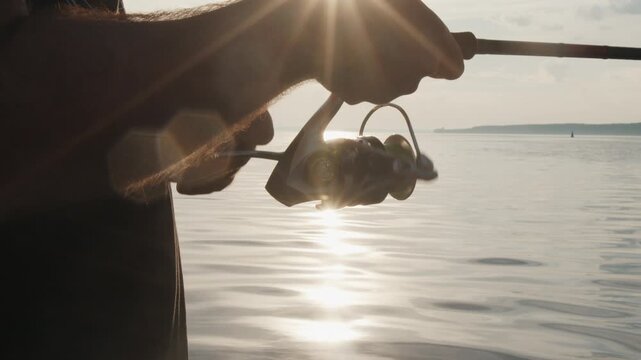 Angler stands in the boat and fishing on the lake