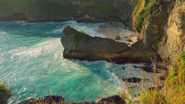 Close View of Hidden Sandy Cove With Turquoise Water and Rugged Coastal Cliffs at Korawa Beach in Slow Motion