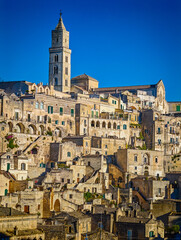 Fototapeta premium Matera. Panoramic view of golden hour sunset at Sassi di Matera in Italy, historic Sassi cave dwellings and ancient stone architecture in Basilicata