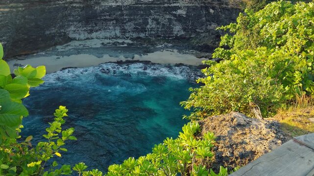Turquoise Ocean Cove Surrounded by Limestone Cliffs and Tropical Vegetation at Broken Beach During Golden Hour in Slow Motion