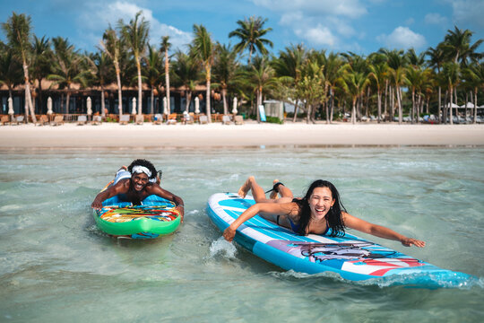 Happy young couple sharing a joyful moment on surfboards during a tropical vacation