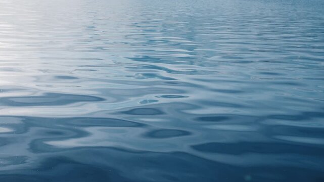 Calm water surface with reflection of the summer clouds