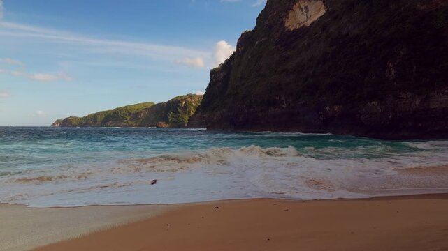 Strong Waves Washing Across the Shore at Kelingking Beach Below Massive Coastal Cliffs in Slow Motion