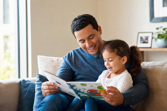 Pai lendo livro ilustrado para sua filha pequena em um sof&aacute; aconchegante - Conceito de educa&ccedil;&atilde;o, carinho paterno e tempo de qualidade em fam&iacute;lia.
