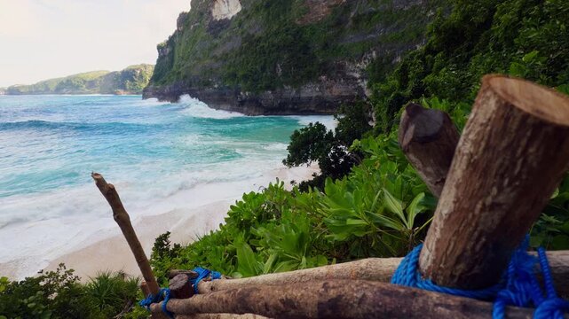 Steep Trail Overlooking Kelingking Beach with Turquoise Water and Powerful Surf Below in Slow Motion