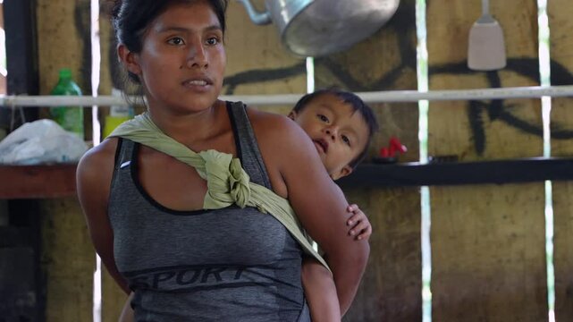 Indigenous mother carrying her child on her back