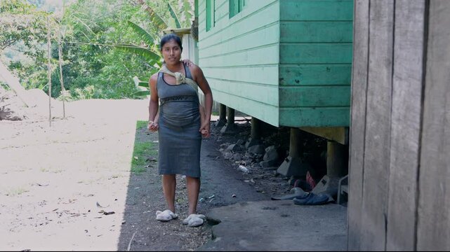Indigenous mother carrying baby in a rural village