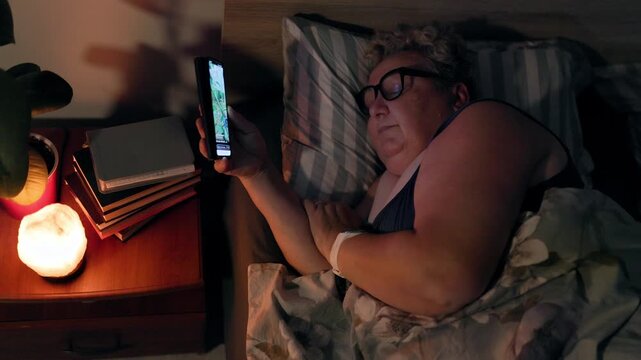 Overweight Tired Mature Woman Falling Asleep In Bed With Smartphone Dropping At Night