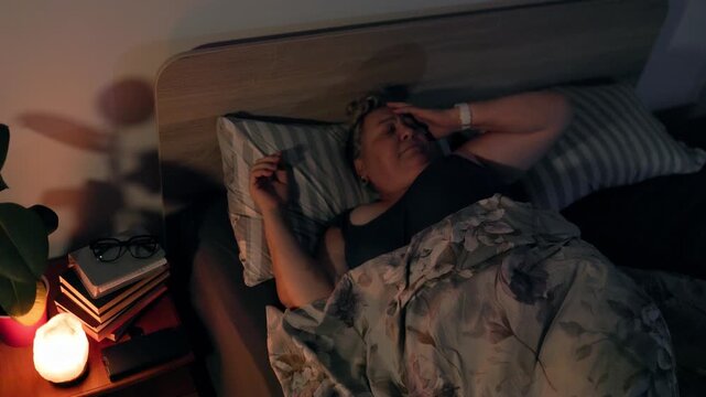 Overweight Exhausted Mature Woman Adjusting Sleep Position in Bed at Night