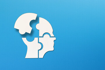 Mental health concept. Human head puzzle pieces on blue background.  © ytemha34