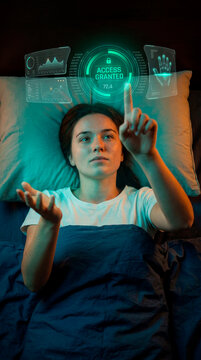 Young woman interacting with floating access granted hologram from bed at night