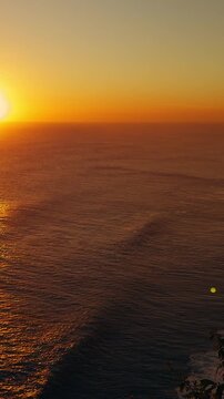 Vertical video. Timelapse Sunset Over Karang Boma Cliff And Endless Ocean With Golden Reflection Across Water, Coastal Serenity And Natural Beauty