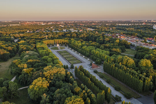 Aerial view of the Soviet War Memorial in Treptower Park surrounded by lush green trees and pathways during sunset in Berlin, Berlin, Germany.
