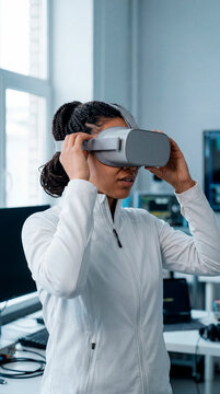 Young woman adjusting virtual reality headset in bright modern technology lab