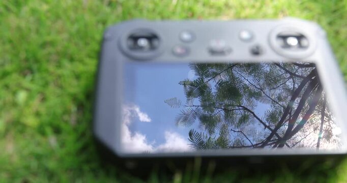 Broken drone remote controller on the green grass