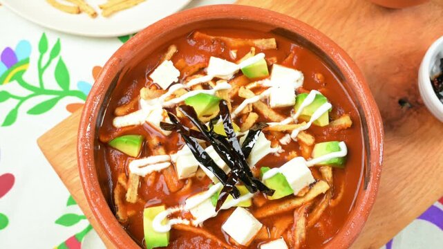 Aztec soup or sopa de tortilla. Homemade Mexican food served in rustic clay plate