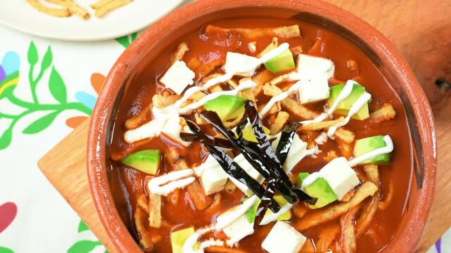Mexican food. Traditional tortilla soup served in a clay bowl. Close-up view