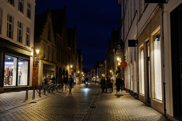 Fototapeta premium Nighttime street scene in historic town center with shops