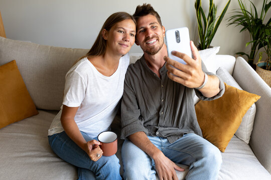 Young couple using mobile phone at home