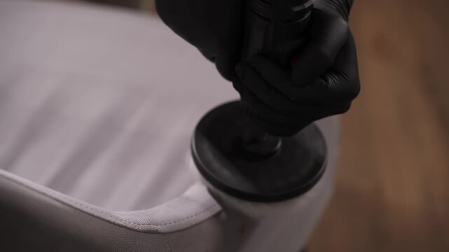 Chair fabric stain treatment utilizing a spinning drill brush shot in 4K. Cleaning service agitates upholstery before deep dirt extraction