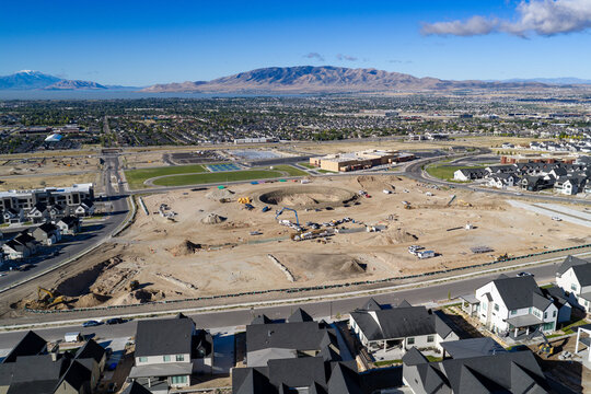 Aerial view of the Lehi Temple construction project at Silicon Slopes showing earthworks, Utah Lake, and residential neighborhoods in Lehi, Utah, United States.