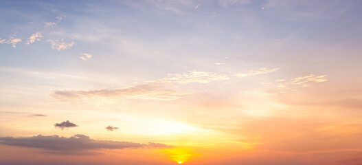 Obraz premium Beautiful sunset sky background with soft pastel orange light and bright golden sun glow for panoramic travel mockup design