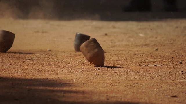 Close-up footage of a traditional Hmong wooden spinning top used in the cultural game known locally as "Dao Tawl Lu" during a hill tribe festival in Northern Thailand. The spinning top stands in sharp